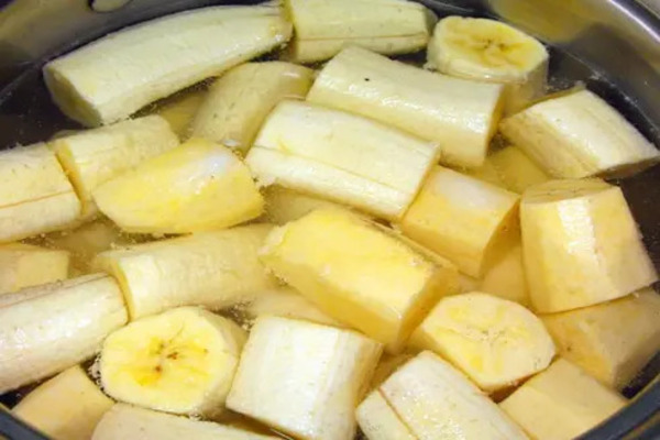 Plátano troceado en un cazo con agua